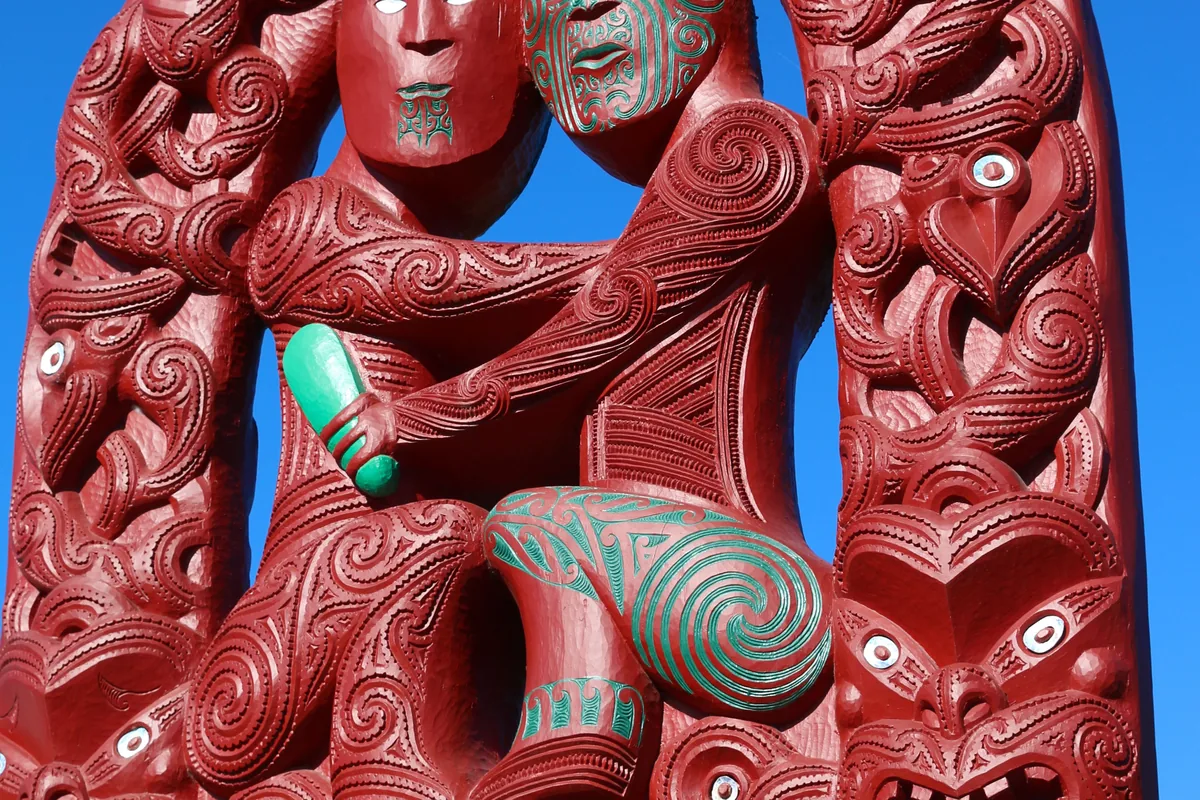 Una talla tradicional maorí en madera, fotografiada en Rotorua contra un cielo azul