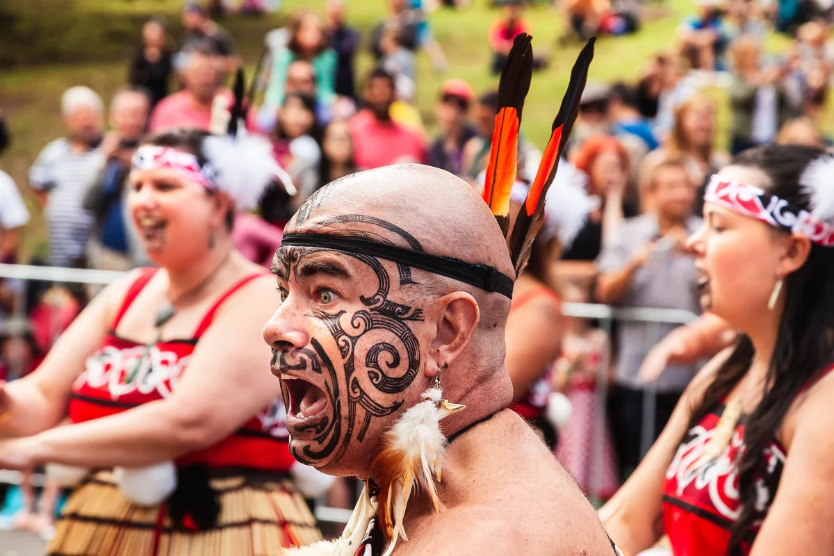 Un intérprete maorí con el tradicional tatuaje facial ta moko, actuando en un festival diurno
